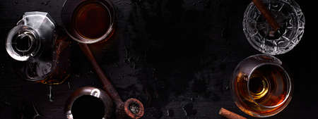 Banner of Glass of whiskey with smoking cigar on dark wooden table. Top view. Copy space.の写真素材