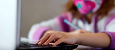 Unrecognizable girl, Schoolgirl studying at home with a notebook and doing school homework. Distance...