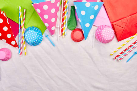 Birthday flat lay, top view and copy space for text, frame or background with colorful festival items, party hats and streamers, Birthday or party greeting card.の写真素材