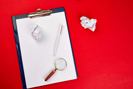 Flat lay of concept of search idea, goals, Business image, Magnifying glass and crumpled paper on red background, Finding the best idea and inspiration among others, Search Engine Marketing.の写真素材