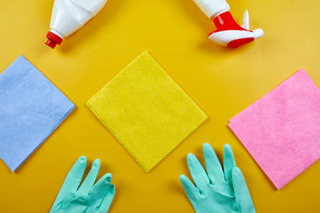 Flat lay of variety house cleaning product on yellow table with copy space, cleaning set for...