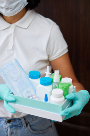 Medicine woman courier in mask and gloves with medical pills purchases during the prevention of coronovirus, Safety home and quarantine concept, Volunteer with Donation goods.の写真素材