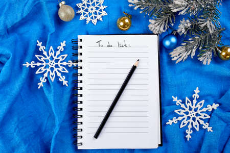 Top view of blank notebook for to do list and christmas decoration on blue textile linen tablecloth background, flat lay, copy space, new normal year.の写真素材