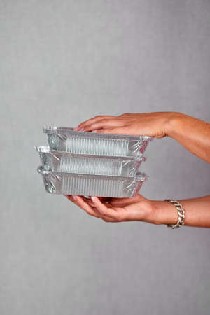 Closeup courier hand hold go box food, delivery service, isolated on grey background studio,...