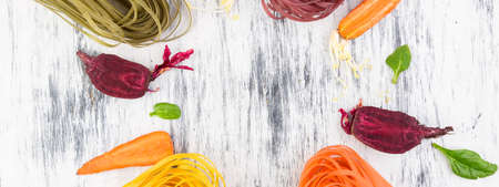 Banner of Colored Raw Vegetable Vegetarian Pasta with Beets, Carrots and Spinach. Flat lay. Copy...