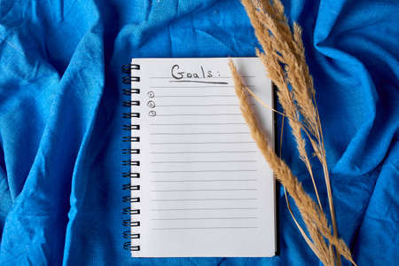 Flat lay top view notebook, notes with pampas grass on tablecloth background, Future family, house, life goals and plan or starting a new business, concept of planning, mock up.の写真素材