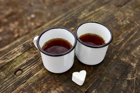 Enameled Two cups of tea in nature on wooden background, love, heart of marshmallow, travel concept, Lifestyle moment at nature, Valentine day, copy space, top view.の写真素材