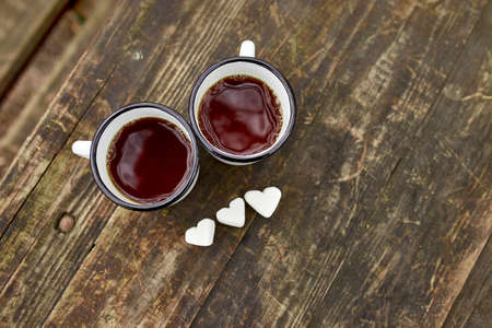 Enameled Two cups of tea in nature on wooden background, love, heart of marshmallow, travel concept, Lifestyle moment at nature, Valentine day, copy space, top view.の写真素材