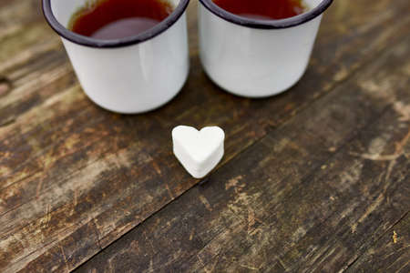 Enameled Two cups of tea in nature on wooden background, love, heart of marshmallow, travel concept, Lifestyle moment at nature, Valentine day, copy space, top view.の写真素材