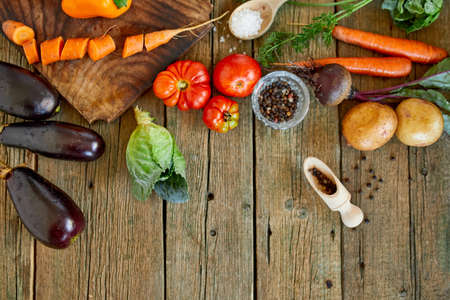 Flat lay of various organic vegetables ingredients and spicy on wooden background, local food, Vegetarian and vegan food, diet spring concept, top view, copy space.の写真素材
