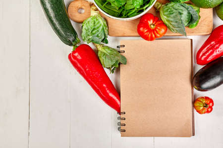 Flat lay of assorted vegetables around cooking recipe book, grocering, local food, healthy clean eating, Vegetarian and vegan food, diet spring concept, top view, copy space.の写真素材