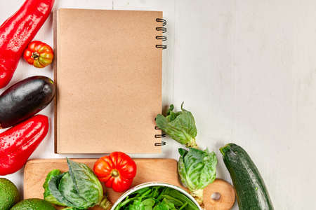 Flat lay of assorted vegetables around cooking recipe book, grocering, local food, healthy clean eating, Vegetarian and vegan food, diet spring concept, top view, copy space.の写真素材