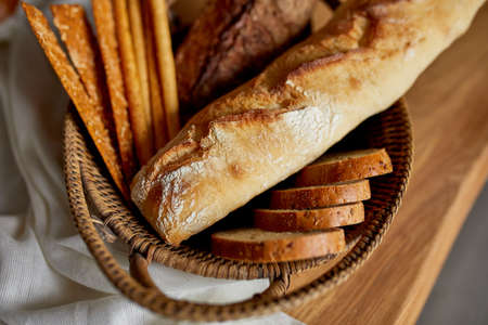 Top view of various kinds of bread on a wooden surface. Close up Concept of homemade bread, small bakery, natural farm products, local food, domestic production. Healthy and tasty organic food.の写真素材