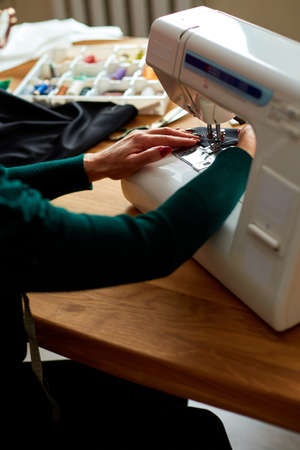 Step by step, 50-yers old woman sews clothes on sewing machine, Mature tailor working with sewing in...
