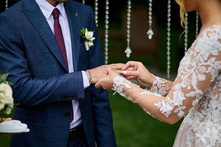 Unrecognizable Bride and groom exchange rings at the wedding. Lovers put each other rings on the fingers, Wedding day,の写真素材