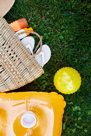 Flat lay of outdoor bright summer beach vacation or travel lifestyle concept with straw bag, flip...