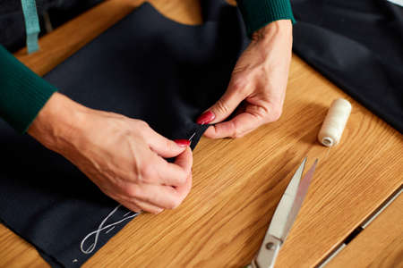 Top view Step by step, 50-yers old woman sewing fabric with hand, Mature tailor working with sewing...