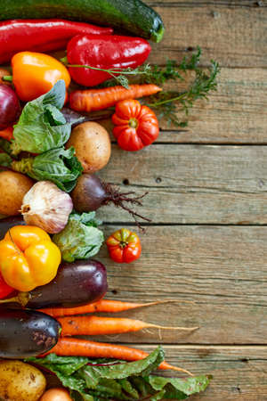 Flat lay of assortment of fresh vegetables, bio healthy, organic food on wooden background, country market style, garden produce, diet veggie food, clean eating.の写真素材