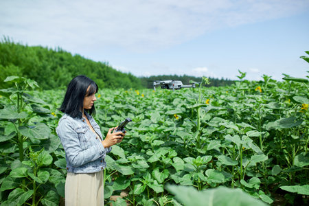 Young woman learning how to pilot her drone in, female using, piloting, fly drone on field of...