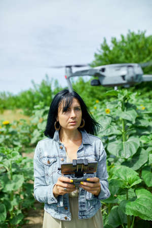 Young woman learning how to pilot her drone in, female using, piloting, fly drone on field of...