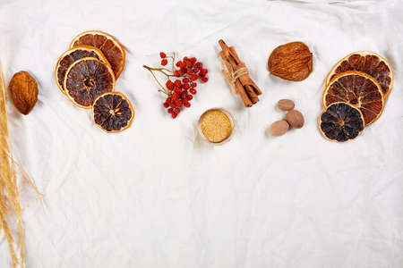 Flat lay of ingredients and bottle of red wine for winter seasonal mulled wine on white textile linen tablecloth, Still life, cloth texture background, Christmas drink, copy space.の写真素材