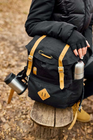 Unrecognizable woman backpacker traveler sitting on bench, travel accessory, relaxing, autumn, break...