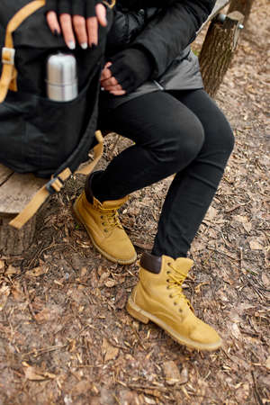 Unrecognizable woman backpacker traveler sitting on bench, travel accessory, relaxing, autumn, break...