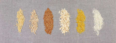 Banner of Flat lay of set of heap various grains and cereals bulgur, rice, oatmeal, buckwheat, couscous wheat seeds on grey background, copy space, space for text, top view.の写真素材
