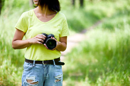 Woman photographer with a photo camera in hand outdoor, World photographer day, creative hobby, copy...