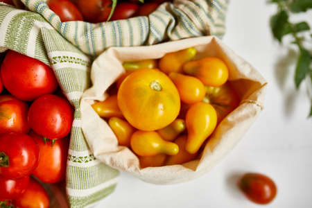 Market delivary of Different kinds of tomatoes in eco textile bag, Zero waste, Eco background,...