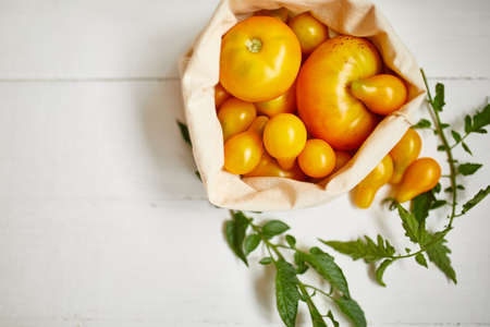 Market delivary of yellow tomatoes in eco textile bag, Zero waste, Eco background, Assortment of...