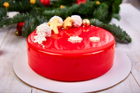 Mousse Christmas pastry cake dessert covered with red mirror glaze with new year decorationsの写真素材
