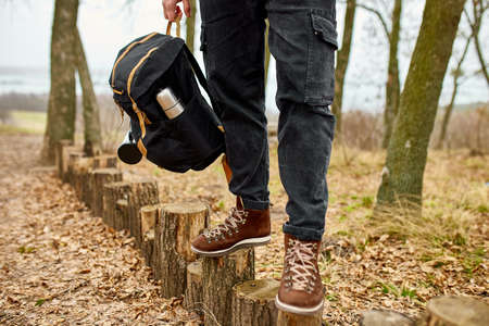Tourist man hold in hand  backpack, Travel concept, Autumn background landscape, travel accessory,...