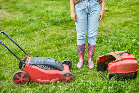 unrecognizable Woman with a lawn mower grass at home garden, gardener woman working, Beautiful summer landscape, sunlight, great design for any purposes, gardening conceptの写真素材