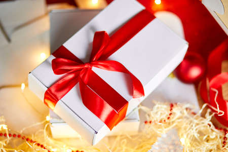 DIY Christmas present wrapping Christmas gift white box with a red ribbon, festive decoration on the table.の写真素材