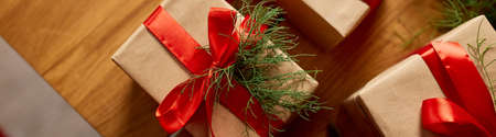 Banner Christmas eco friendly packaging kraft paper and fir branches gifts for the Holiday season, Christmas on wooden table, eco decor, Christmas present gift boxの写真素材