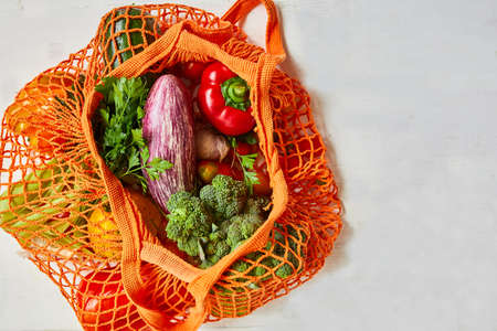 Flat lay Mesh grocery shopping eco friendly bag with vegetable and greens, Zero waste cconcept, Local farmers market, shopping mall, top view, copy space, Plastic free items.の写真素材