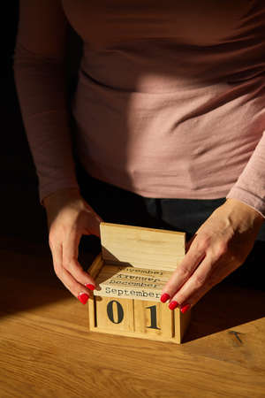 Woman hand change, sets the date on the wooden calendar on 01 January , Happy New year, hard light,...