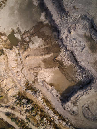 Aerial view of Slope operating granite quarry with mining equipment on ledges, Industrial quarry, heavy industrial machinery working at the mining open pit.の写真素材