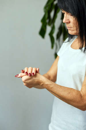 Mature woman applying moisturizing hand cream at home, Concept of health care of the handの写真素材