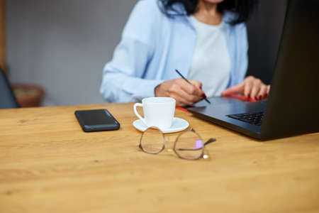 Mature woman designer using graphics tablet and stylus, working at laptop, using computer and digitizer at creative officeの写真素材