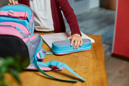 Schoolgirl put books and notes into backpack at home, pupil prepare staff for education, School...