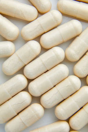Flat lay macro White beige capsule pills, tablets, top viewの写真素材