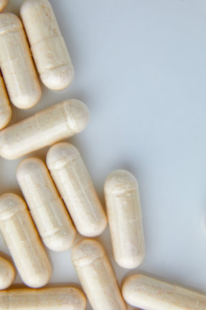 Flat lay macro White beige capsule pills, tablets, top view, close up texture background...
