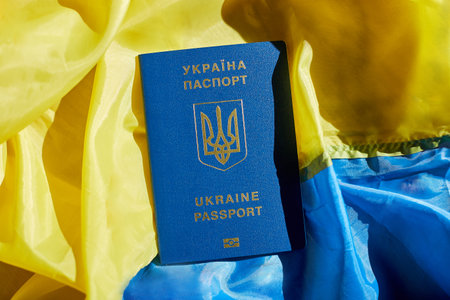 Ukrainian biometric passport on the flag of Ukraine, immigration because war, Euoropeの写真素材