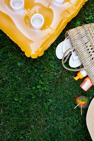 Flat lay of outdoor bright summer beach vacation or travel lifestyle concept  with straw bag, hat,...