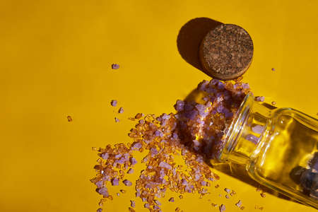 Flat lay bottle sea salt with natural spa products cosmetic, product mockup with water wave,, clean aqua splashing on yellow background sunlight, summerの写真素材