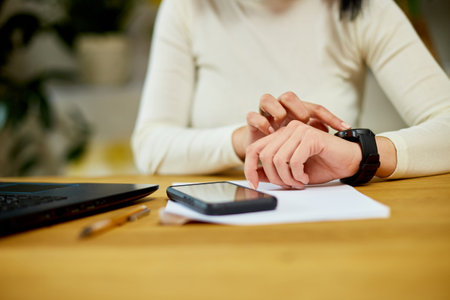 Unrecognizable woman using smartwatch, Freelancer female with smart watch on female wrist, using touchscreen on gadgetの写真素材