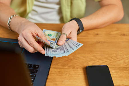 Businessman hands counting cash american dollars banknotes, Finance and money payment concept, Close up male hands counting money, sitting at the table , Income and Businessの写真素材