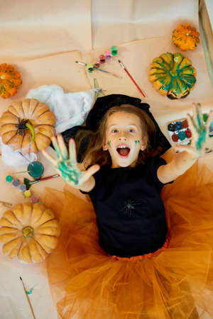 Top view of Smiling girl lying on the floor between drew pumpkin Halloweenの写真素材